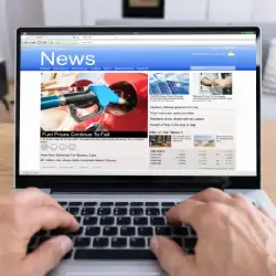 Hand using laptop with creative glowing content text on blurry background.