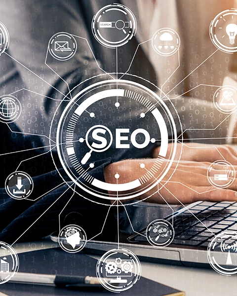 A person typing on a laptop, surrounded by digital icons representing SEO strategies and analytics concepts.